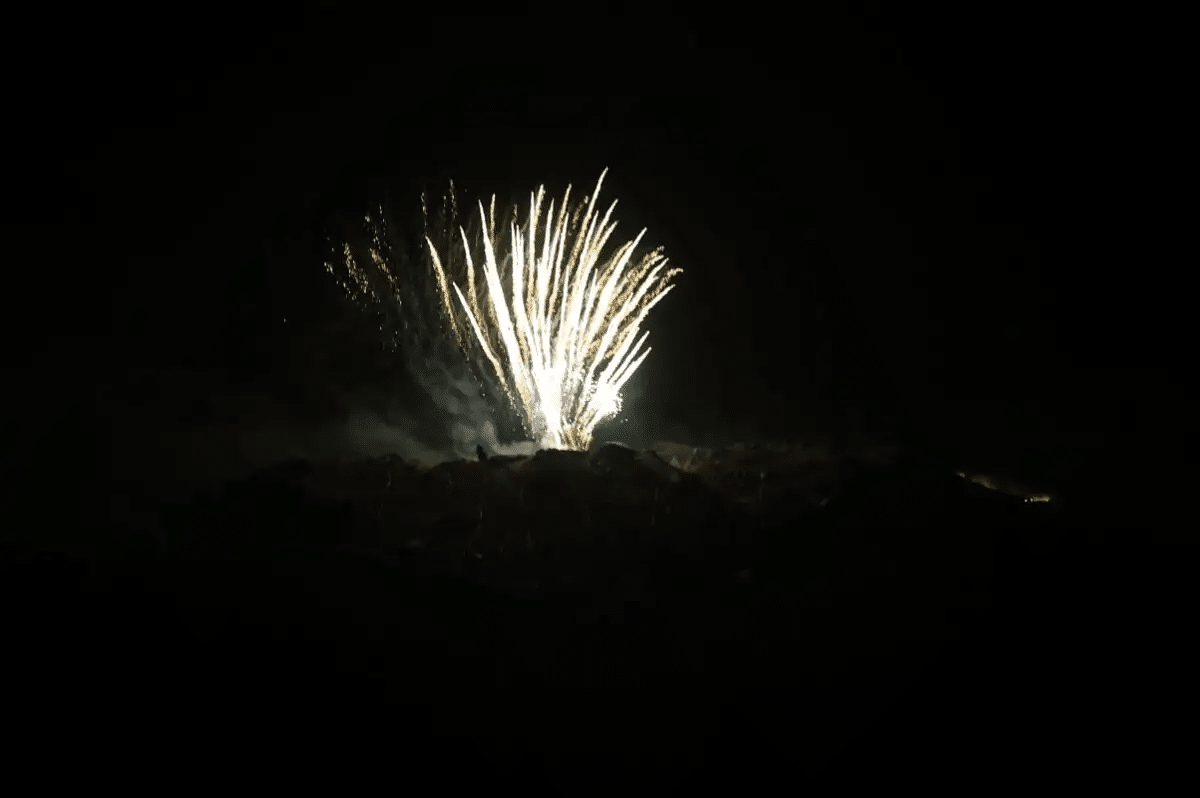 Golden fireworks rising from the volcanic island